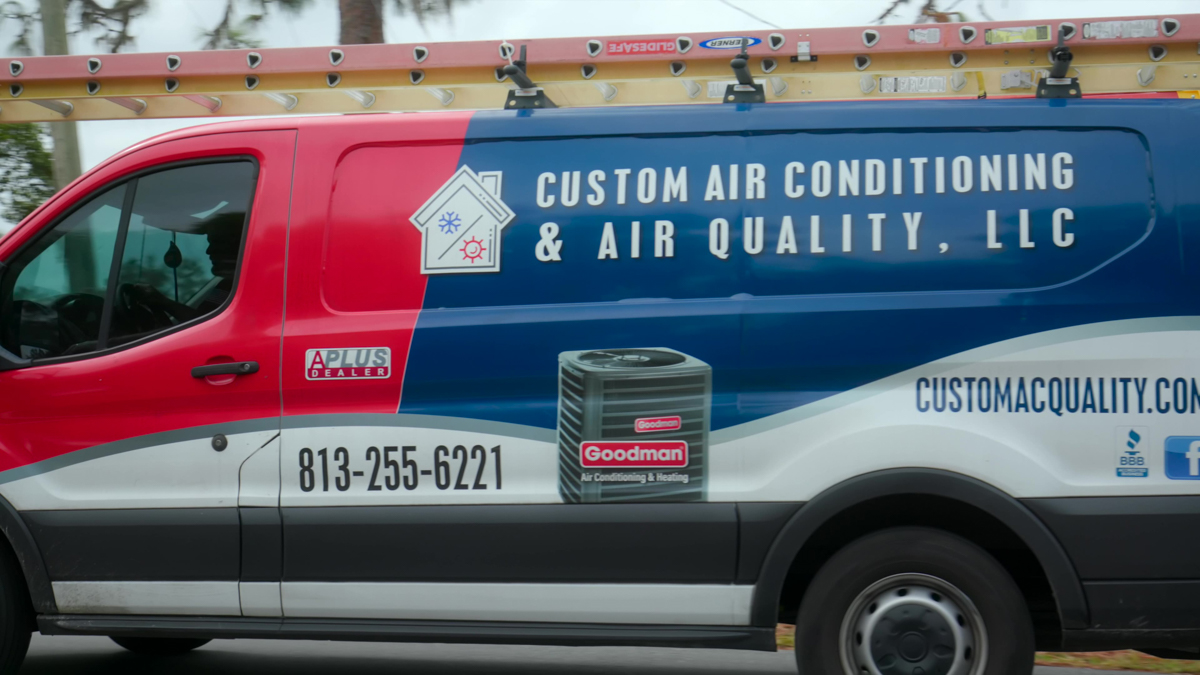 Custom air conditioning and air quality service truck driving through a residential neighborhood 1