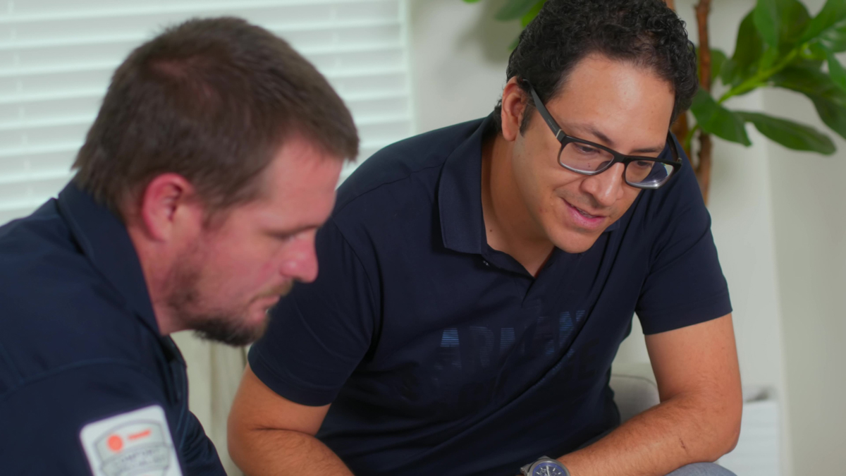 Custom air conditioning and air quality technician discussing hvac with a homeowner 1
