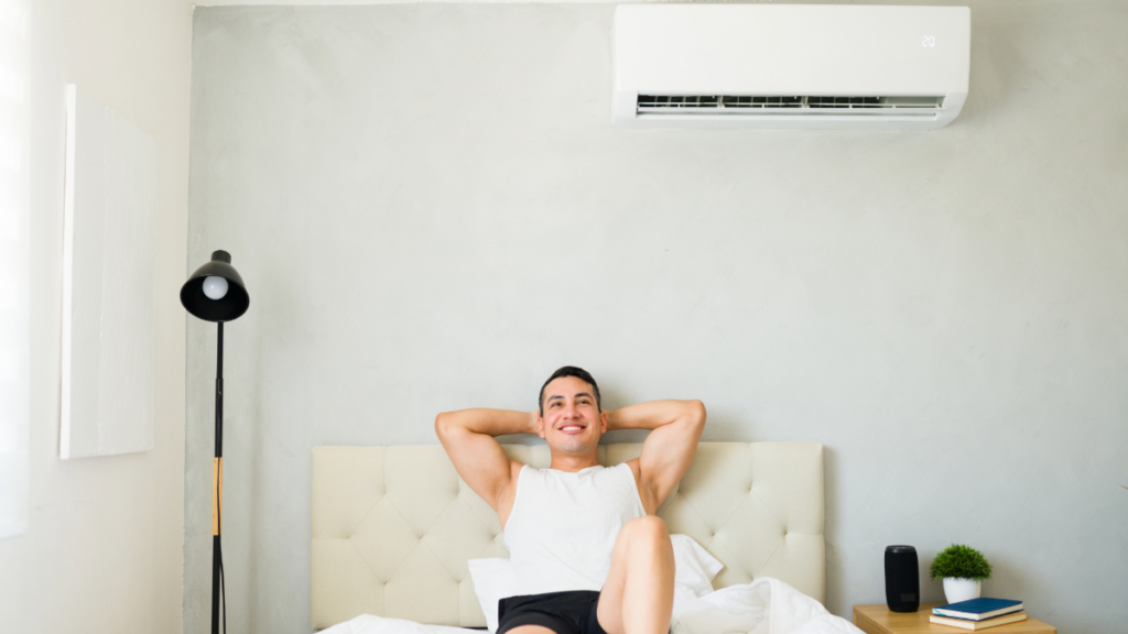 a man enjoying the climate in a room controlled by a ductless mini split ac unit 1024x576 1